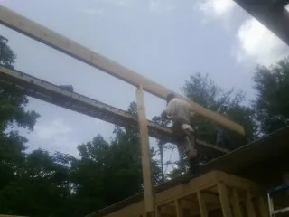Carpenter setting a ridge beam over a new addition frame — Ice Dam Removal by Roofing Brothers in Midway Park
