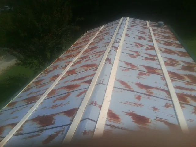 Rusted metal roof panels with new wood purlins before replacement — Storm Damage Roof Repair in Midway Park by Roofing Brothers