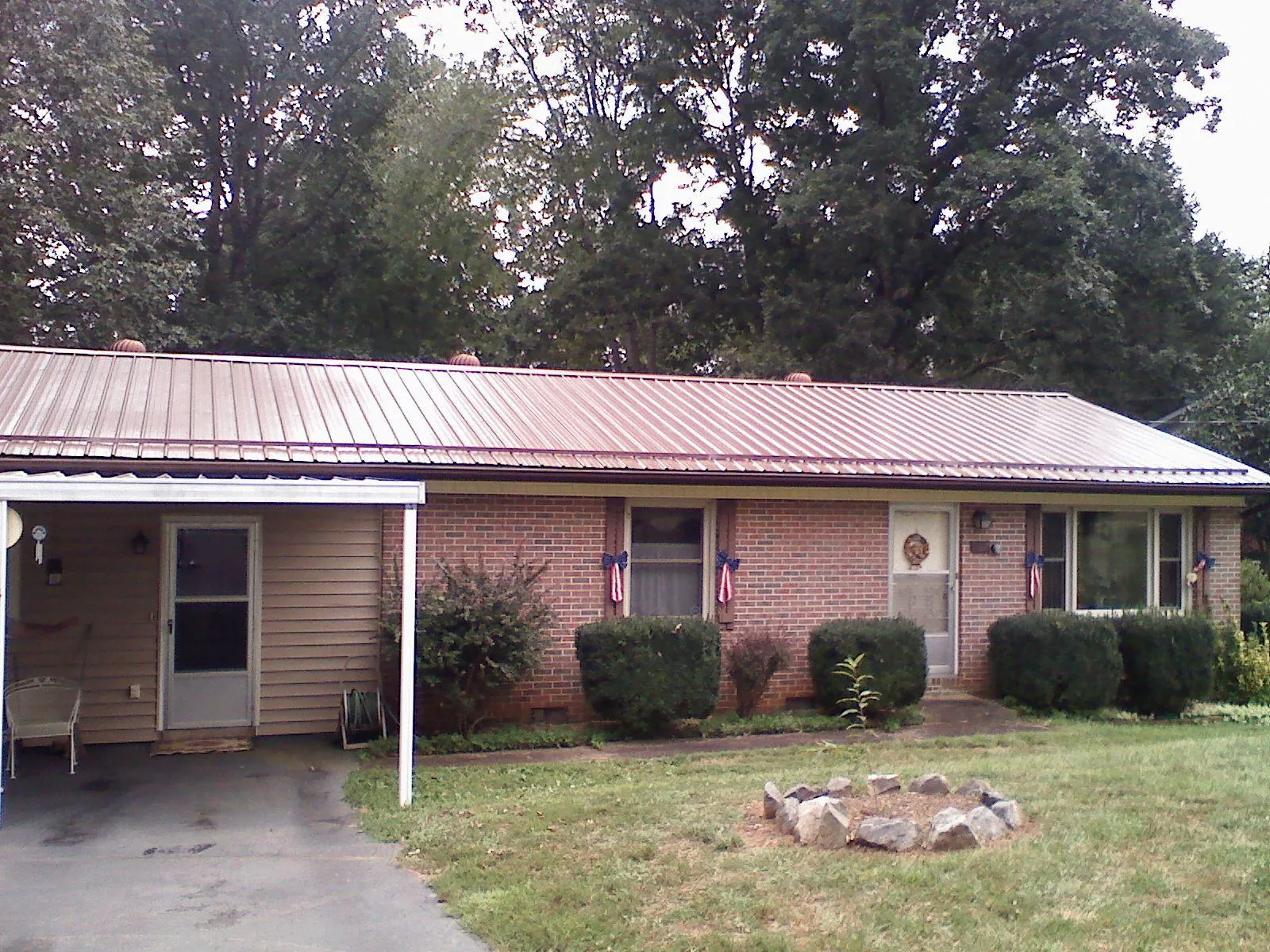 Bronze metal roof and carport on a brick ranch home — Roof Repair work by our crew in Midway Park