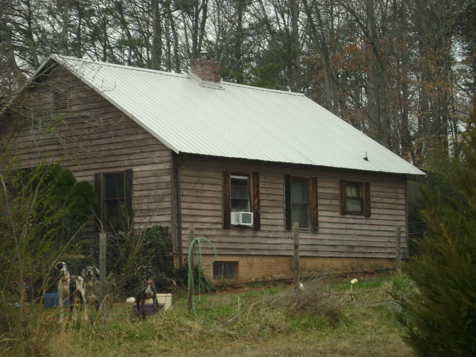 White metal roof on an old wood sided farmhouse, from a Metal Roof Installation job in Midway Park